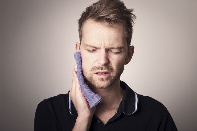 Man-in-pain-holding-his-cheek-with-hand-suffering-from-bad-tooth-ache