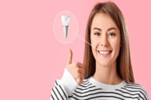 Young woman smiling and giving a thumbs up with a diagram of her dental implant off to the side